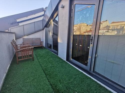 a balcony with a bench and green grass at CTS Elysium Residence Taksim in Istanbul