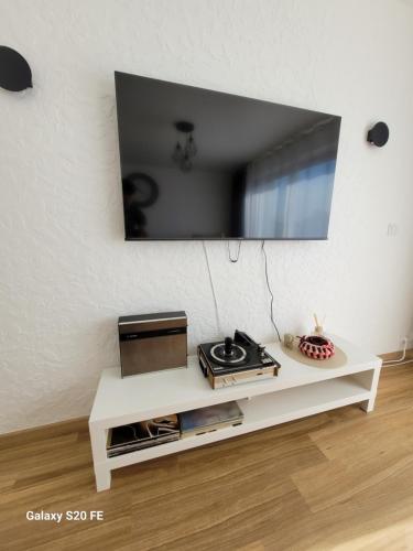 a living room with a tv on a white wall at Appartement à Sainte-Brieuc T3 CESSON in Saint-Brieuc
