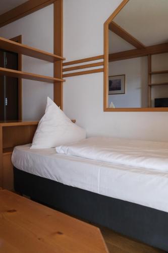 two beds in a room with a mirror at Ferien & Wellnesshotel Windschar in Brunico