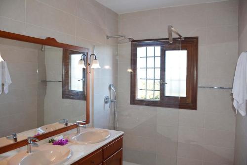 ein Badezimmer mit zwei Waschbecken und einer Dusche in der Unterkunft Charming Traditional Sea View Home in Es Cana