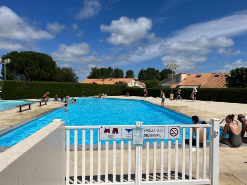 - une piscine avec des personnes debout autour dans l'établissement Maison la palmyre, aux Mathes