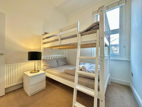 a bedroom with a bunk bed with a ladder at Clapham apartment in London