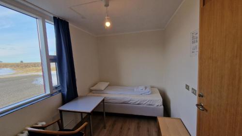 a small room with a small bed and a window at Hunavellir Guesthouse in Blönduós