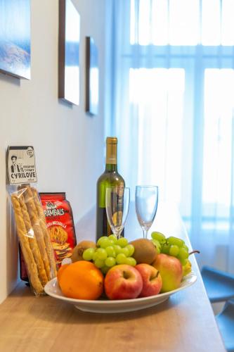 a plate of fruit and vegetables on a table with a bottle of wine at Hotel Granit Nová Polianka*** - klimatické kúpele in Vysoké Tatry