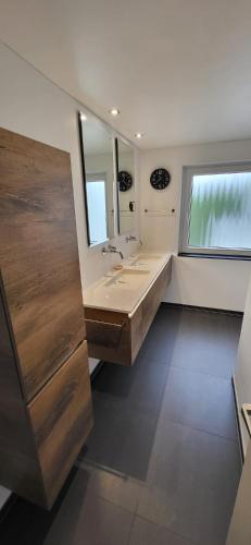 a bathroom with a sink and a large mirror at Landhuis de heibloem in Heythuysen