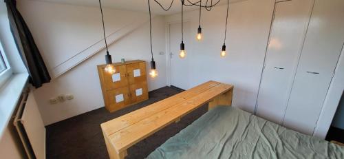 a room with a wooden bench in a room with lights at Landhuis de heibloem in Heythuysen