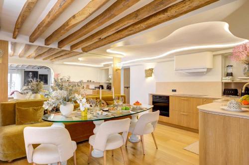 une cuisine et une salle à manger avec une table et des chaises dans l'établissement Elegance et Confort au Coeur de Paris, à Paris