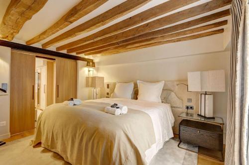 une chambre avec un grand lit avec des serviettes dessus dans l'établissement Elegance et Confort au Coeur de Paris, à Paris