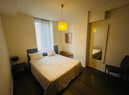 a bedroom with a bed and a large window at Le Prestige de la Mairie in Bourg-lès-Valence