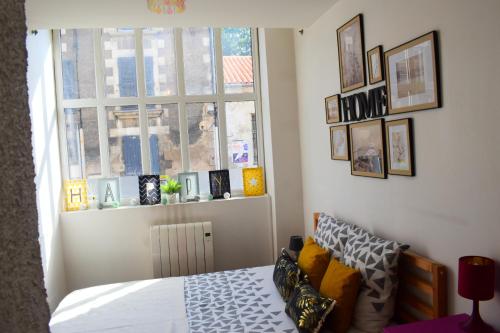 ein Schlafzimmer mit einem Bett und einem Fenster in der Unterkunft Logement cozy proche du centre-ville in Poitiers