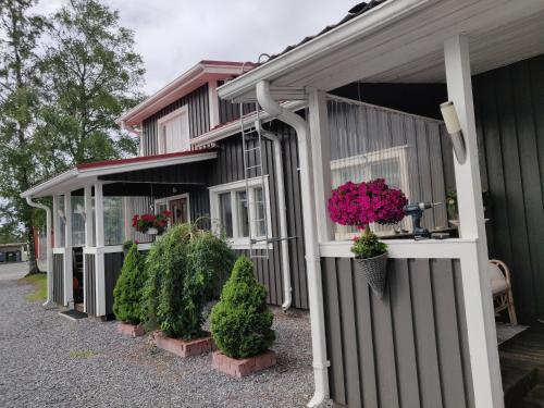 a house with potted plants on the side of it at Vainioranta, koko huoneisto in Perälä