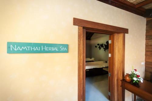 a sign on a wall next to a room at Buri Rasa Village Phangan in Thong Nai Pan Noi