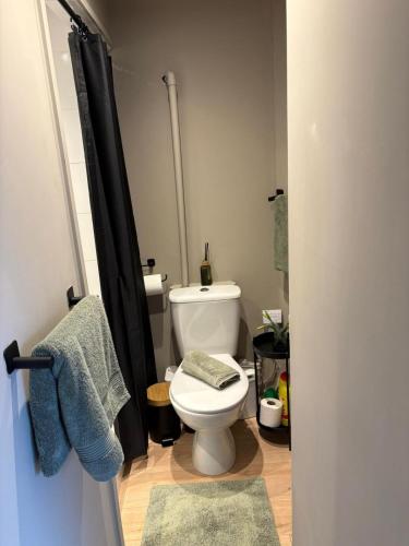 a bathroom with a toilet and a black shower curtain at Waters edge Pontypridd in Treforest