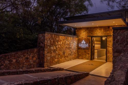a stone building with a sign on the door at Cradle Boutique Hotel in Lanseria
