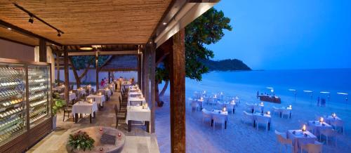 a restaurant on the beach with tables and chairs at Buri Rasa Village Phangan in Thong Nai Pan Noi