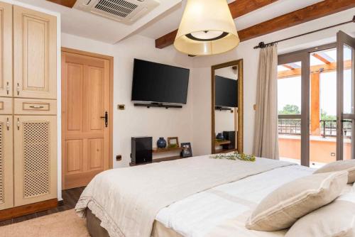 Schlafzimmer mit einem großen Bett und einem Flachbild-TV in der Unterkunft Luxury Villa Finessa Skradin 1 with heated pool, jacuzzi and sauna in Skradin
