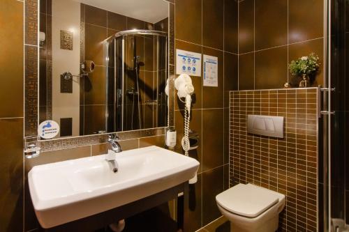 a bathroom with a sink and a toilet at Hotel Mieszko in Gorzów Wielkopolski
