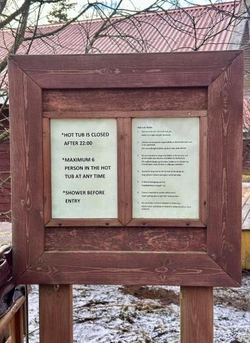 a picture of a sign in a wooden frame at Cozy, forest cabin #11 in Hvolsvöllur - Self check-in, outside jacuzzi! in Hvolsvöllur