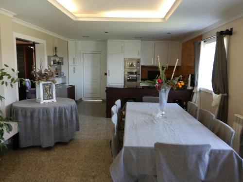 a dining room with two tables and a kitchen at Casa dos Barros - Vitorino dos Piães in Vitorino dos Piães
