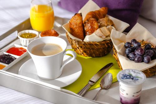 a tray of breakfast foods and a cup of coffee at Eau Thermale Avène l'hôtel in Avène