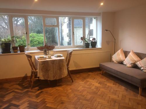 a living room with a table and a couch at Holly Lodge, Gilchristland Organic Farm cottage in Closeburn