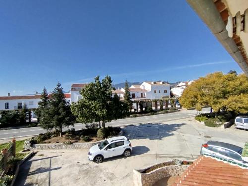 a small white car parked in a parking lot at Merino Casa Rural in Yunquera
