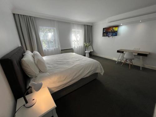 a hotel room with a bed and a desk and a desk at Near CTICC Professional & Cosy Hotel Room in Cape Town