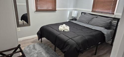 a bedroom with a bed with two shoes on it at Cozy 3BR Home near Casinos! in Mohegan