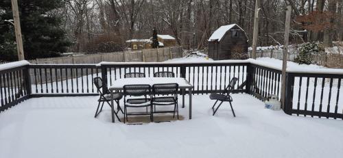 a table and chairs in the snow on a fence at Cozy 3BR Home near Casinos! in Mohegan