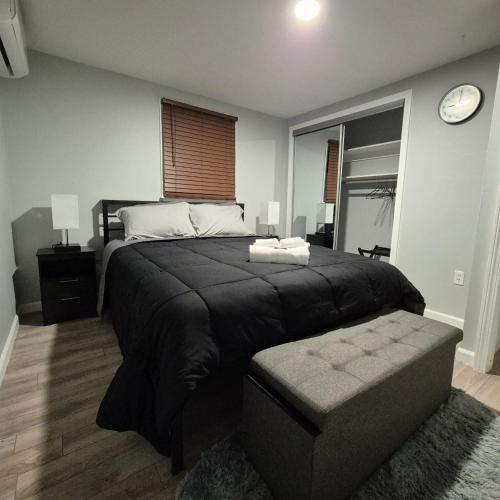 a bedroom with a large bed and a clock on the wall at Cozy 3BR Home near Casinos! in Mohegan