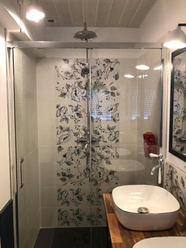 une salle de bain avec une douche en verre et un lavabo dans l'établissement Maison face à la Mer, à Étel