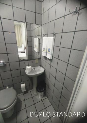 a small bathroom with a toilet and a sink at Titão Plaza Hotel in Campina Grande