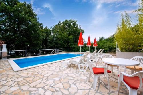 Un patio con mesa y sillas y una piscina. en Vinez, en Labin