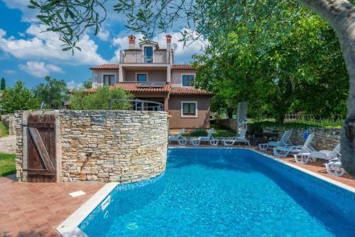 una villa con piscina y una casa en Villa Arco, en Juršići
