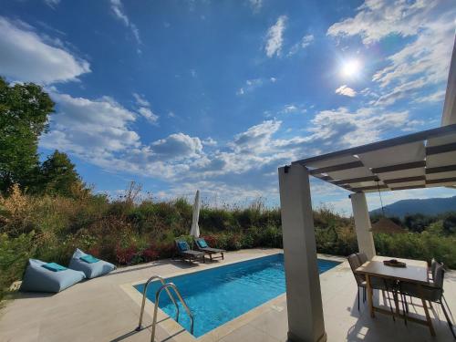 a swimming pool with a table and chairs next to at Neues Ferienhaus In Thasos Mit Großer Terrasse in Potamia