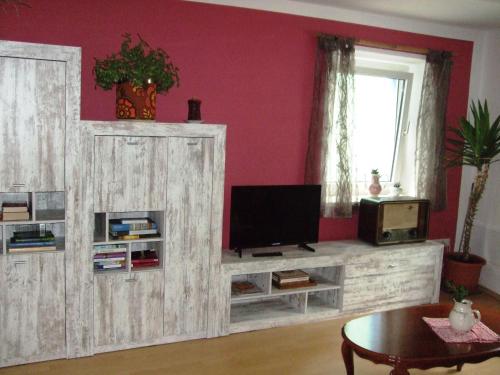 sala de estar con TV y centro de entretenimiento de madera en Ferienwohnung Örtl In Obernzell, en Obernzell
