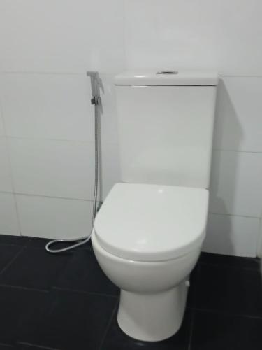 a white toilet in a bathroom with a hose at Green Peak - Mountain View Hotel & Restaurant in Ella
