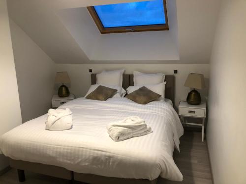 une chambre avec un lit blanc avec des serviettes dessus dans l'établissement Domaine de Mandrin, à Madranges