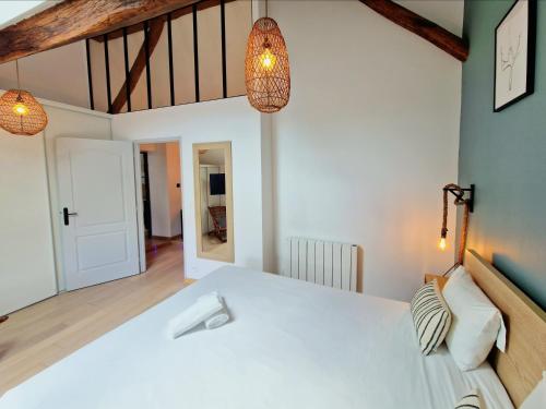 a bedroom with a white bed and two lights at L'atelier De Neuville in Neuville-sur-Oise