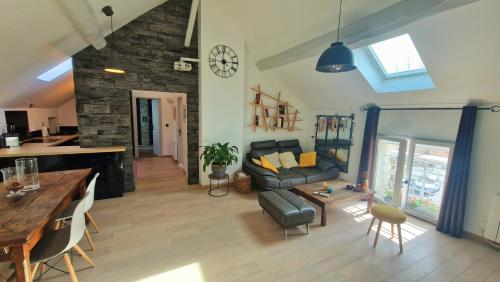 a living room with a couch and a table at L'atelier De Neuville in Neuville-sur-Oise