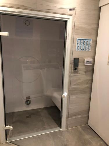 une douche avec une porte vitrée dans une salle de bain dans l'établissement Domaine de Mandrin, à Madranges