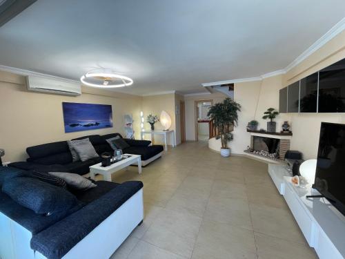 a living room with a couch and a tv at Bungalow on the beach 15 minutes from Valencia in Valencia