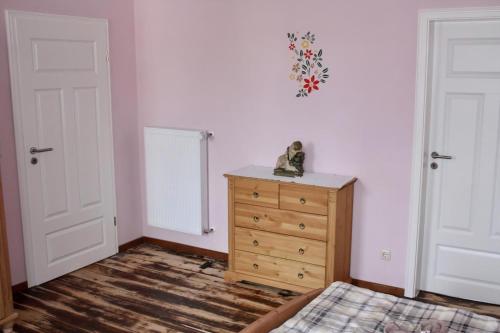 a bedroom with a wooden dresser and two white doors at Ferienhaus Schäwisch in Dreis-Brück