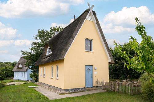 a small yellow church with a black roof at Ferien Im Reethaus Seepferdchen in Gramkow