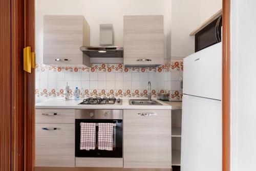 a kitchen with a stove and a white refrigerator at Casa Natalina in Recco