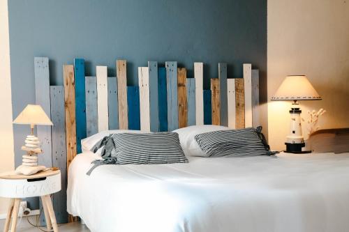 - une chambre avec un grand lit blanc et une tête de lit en bois dans l'établissement Terrasse vue mer pour 2 personnes, Plouguerneau, à Plouguerneau