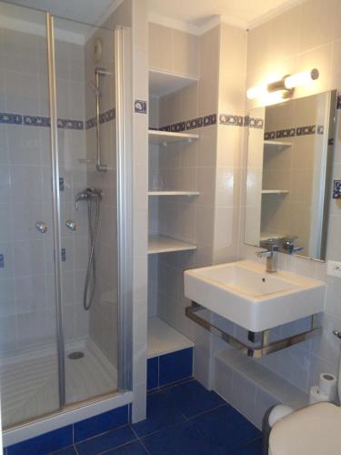 une salle de bain avec un lavabo et une douche dans l'établissement Appartement 1 chambre, parking et piscine, à Sète