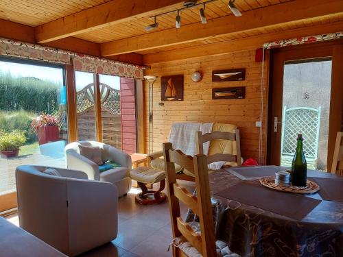 d'un salon avec une table et des chaises ainsi que d'une terrasse. dans l'établissement Face à la mer, maison sur la dune pour 4 personnes, à Plouguerneau