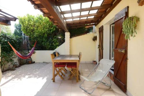 a table and chairs on a patio with a roof at Jolie Chambre chaleureuse in Marseille