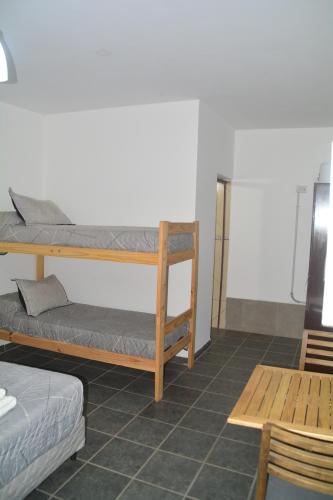 a room with two bunk beds and a table at Posada Los Angeles de Talampaya in Villa Unión